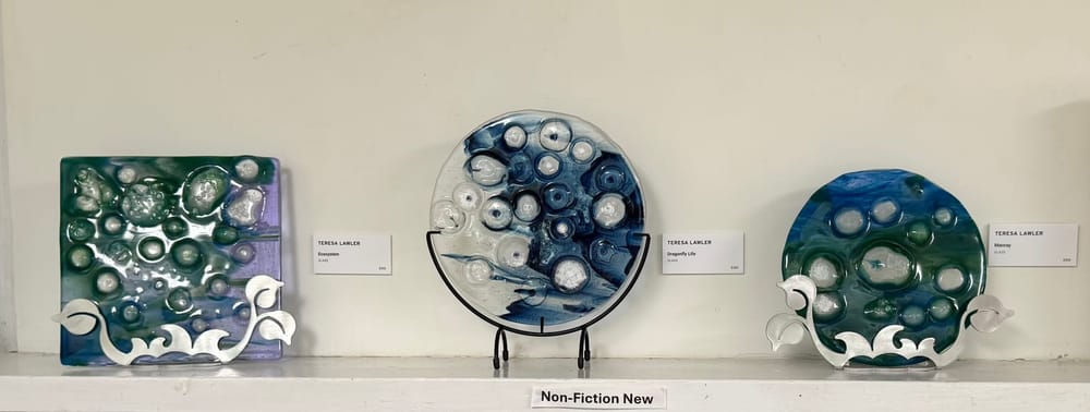 Three fused-glass pieces with bubbled texture on display