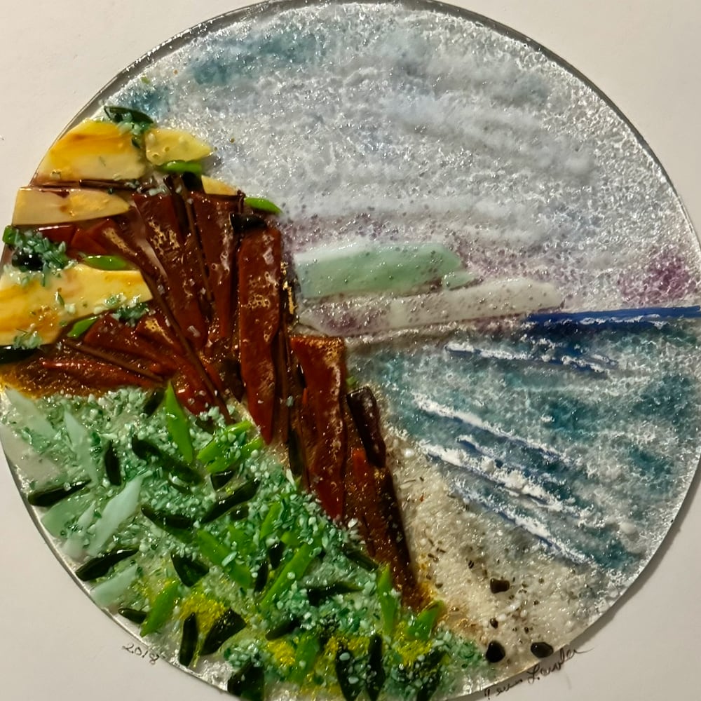 Round fused-glass platter with cliffs and sea in misty blues and greens